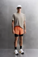 Camiseta deportiva color beige confeccionada en tejido con estructura, ligero y elástico en todas direcciones. Tiene cuello redondo, manga corta, costuras planas y logo estampado en el bajo.