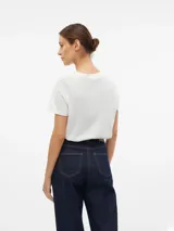 Camiseta blanca de algodón con cuello redondo y mangas cortas. Presenta un bordado en el frente con el contorno de un rostro femenino.
