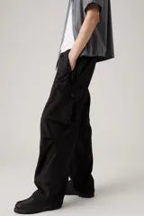 Pantalón cargo negro de corte amplio con bolsillos laterales y cintura ajustable con cordón.