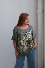 Remera verde militar de lino con estampado abstracto en tonos dorados y negros.