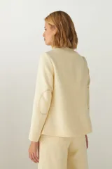 Chaqueta corta con cuello solapa, manga larga con coderas aplicadas, cierre frontal con botones y bolsillos ojal. Con forro.