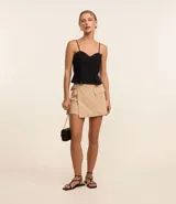 Blusa estilo corset color beige, confeccionada en crepé, con breteles finos, escote corazón, cremallera en la espalda y volado peplum en el bajo.