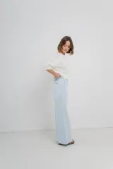 Pantalón de tiro alto, corte palazzo amplio y fluido, color celeste claro. Presenta bolsillos delanteros y traseros tipo jean, con logo metálico Peach en la parte posterior.