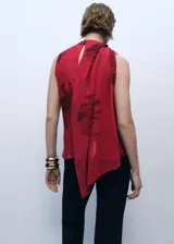 Blusa roja con estampado de flores, cuello drapeado con fular, sin mangas y cierre de botón en la parte posterior.