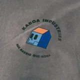 Remera gris de corte oversize con estampa en el pecho con el logo de la marca Kaboa Industries y la frase 'Más barrio que moda'.