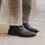 Bota corta marrón con estampado de cocodrilo, taco de madera con folea de cuero y cierre lateral.