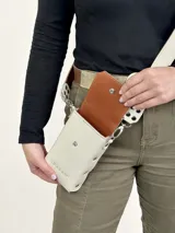 Bandolera porta celular negra de cuero genuino, con correa larga regulable y cierre con broche metálico. Forrada en cuero.