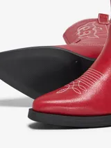 Botas rojas de estilo cowboy con bordados blancos y suela negra.
