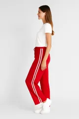 Pantalón negro ancho con rayas blancas laterales y cintura elastizada con cordón ajustable.
