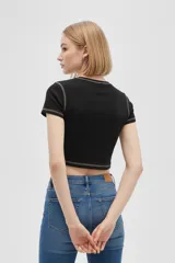 Remera blanca corta de algodón con cuello redondo, mangas cortas y estampado frontal con la frase 'You Give Me The Ick' en color rojo. Tiene pespuntes rojos en cuello y mangas.