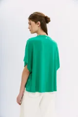 Remera verde con estampado tipo bandana, mangas cortas, cuello redondo y corte amplio con frente cruzado.