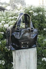 Mini bag color oro rosa metalizado, de cuero, con doble asa corta y logo grabado en el frente.