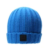 Gorro de lana tejido color azul con etiqueta negra con logo en el frente.