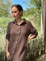 Vestido camisero largo de lino blanco, con corte en la cintura, abertura lateral y botones de nácar.