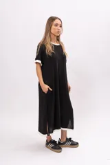 Vestido remerón largo de manga corta color negro, con cuello y puños blancos, y aberturas laterales.