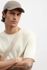 Remera color crema de punto acanalado suave de mezcla de algodón y viscosa. Tiene cuello redondo y mangas cortas con ribete acanalado fino en cuello, puños y bajo.