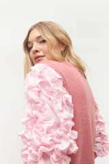 Remera negra de punto con mangas largas abullonadas con volantes.