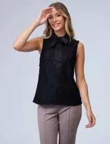 Blusa azul marino de encaje sin mangas, con cuello camisero y lazo al cuello.