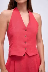 Chaleco color coral con escote halter y cierre frontal con botones.