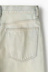 Pantalón de jean color crema, de corte holgado, con tiro bajo y cinco bolsillos.