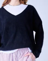 Sweater negro de cashmere cepillada con cuello en V, corte oversize, mangas largas y terminaciones acanaladas.