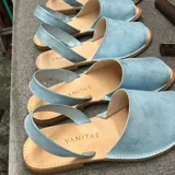 Sandalias tipo abarca color celeste, con capellada cerrada y tira trasera.