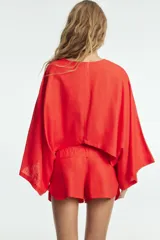 Shorts de tiro bajo color amarillo claro, confeccionado en tejido con lino. Presenta cintura elástica ajustable con cordones y aberturas laterales en el bajo.