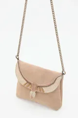 Cartera de mano negra de cuero gamuzado con solapa bordada con diseño de alas en tonos dorados y plateados. Tiene cierre magnético, bolsillos internos y cadena metálica dorada vieja.