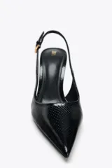 Zapato de tacón negro con efecto relieve en el cuerpo, tira trasera con hebilla ajustable, tacón fino y acabado en punta.