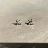 Aros pequeños de acero en forma de estrella con detalles brillantes.