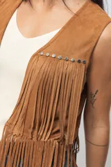 Chaleco negro de gamuza sintética con flecos y tachas plateadas.