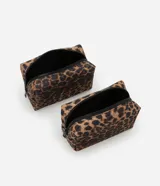 Kit de tres neceseres: uno grande transparente con asa y dos medianos con estampado animal print de leopardo y cierre de cremallera.