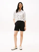 Pantalón corto chino de corte Mom, color negro, con bolsillos laterales y traseros. Presenta bajos con vuelta y logo de Tommy Hilfiger bordado en la parte trasera.