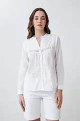 Camisa blanca de manga larga con bordados en el frente y cuello.