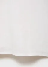 Camisa blanca de manga corta confeccionada en mezcla de algodón y lino, con cierre frontal de botones, cuello camisero y corte recto.