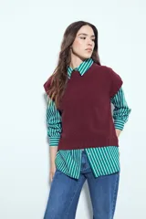 Chaleco tejido sin mangas de color negro, con cuello redondo y diseño de textura sutil. Presenta un corte recto con terminaciones acanaladas en el ruedo y hombros levemente estructurados.