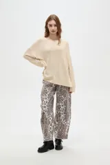 Sweater holgado de poliéster y lurex, color beige, con cuello redondo y manga larga.