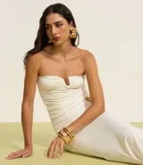 Blusa sin breteles confeccionada en jersey color blanco, con detalle de adorno en forma de U en el busto y fruncidos laterales.