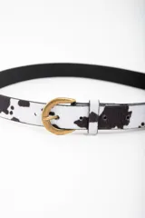 Cinto de cuero con estampado de vaca y hebilla dorada.