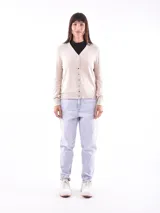Saco de tejido de punto color beige, con cuello en V y cierre frontal con botones.