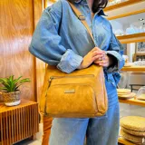 Bandolera color marrón con dos bolsillos frontales con cierre, apertura superior con cierre, bolsillos internos con cierre y abiertos, bolsillo trasero con cierre y correa larga regulable al tono.