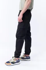 Pantalón cargo jogger color negro con cintura elastizada ajustable con cordón y puños elastizados.
