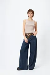 Musculosa de punto color beige, con textura acanalada y detalle de trenzado lateral ajustable.