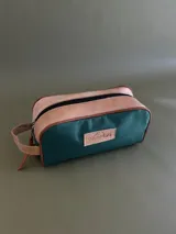 Neceser de lona verde con detalles en cuero color beige y etiqueta con logo de la marca Sierra Mora.