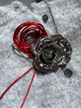 Gargantilla con cordón rojo ajustable y dije de rosa plateada.