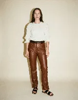 Pantalón de cuero vacuno color marrón, con forrería interna de satén y presillas fruncidas.