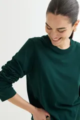 Remera verde oscuro de algodón, de manga larga y corte recto.