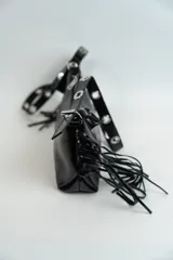 Bandolera negra de cuero sintético con flecos y correa de hombro con estampado de logos.