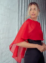 Capa corta color verde esmeralda de gasa transparente, con cuello redondo y abertura frontal con cierre de botón.