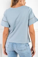 Remera celeste de algodón peinado, con cuello redondo y mangas cortas con detalle de calado.